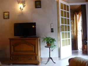 a living room with a flat screen tv on a wooden entertainment center at Gîte dans propriété périgourdine in Pechpialat