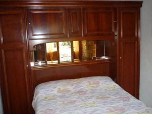 a wooden cabinet with a bed in a room at Gîte dans propriété périgourdine in Pechpialat +12 photos
