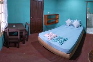 um quarto com uma cama, uma mesa e uma mesa; em Valerie Emanuel Apartments em Bocas del Toro