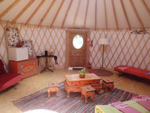 an interior of a yurt with a table and a room at Eco-hôtel et Yourtes du Mercantour in Guillaumes