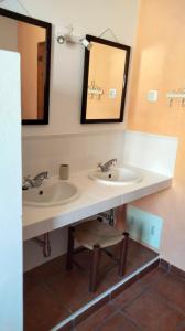 a bathroom with two sinks and a mirror at Monte Sul da Pintada in Montemor-o-Novo