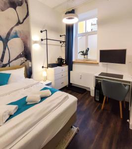 a bedroom with a bed and a desk with a computer at HOMELY STAY Studio 1 in Munich