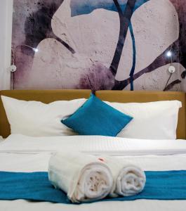 un letto con lenzuola bianche e cuscini blu di HOMELY STAY Studio 1 a Monaco