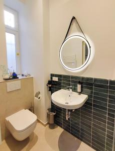 a bathroom with a toilet and a sink and a mirror at HOMELY STAY Studio 1 in Munich