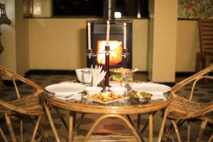 a table with plates of food on it with a candle at SLEEPING BUDDHA VIEW in Shimla