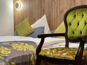 a bedroom with a bed and a chair with a blanket at HHotel Augsburg in Augsburg