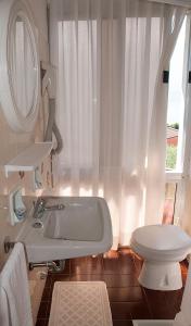 a white bathroom with a tub and a toilet at Hotel Garden in Limone sul Garda