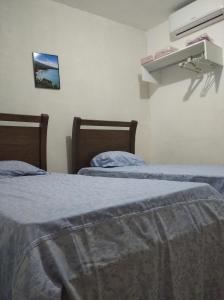duas camas num quarto de hotel com lençóis azuis em Flat estação em Juazeiro do Norte