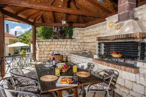 a patio with a table and chairs and a fireplace at Villa Theaya in Nisaki