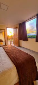 a bedroom with a large bed with a large window at Pousada Vila do Sol Corumbau in Corumbau