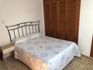 1 dormitorio con 1 cama y armario de madera en Casas Juani centro 1 en Conil de la Frontera