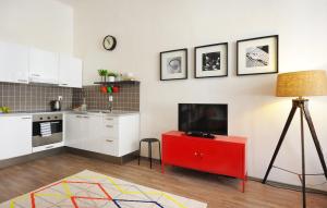 a kitchen with a red cabinet with a tv on it at Cosy Design Apartment in Brno