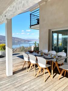 uma sala de jantar com uma mesa e cadeiras num deque em Villa Zenitude em Veyrier-du-Lac