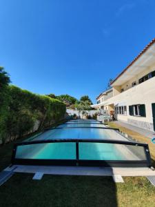 a large glass pool in the backyard of a house at Lisbon Coast Family Home in São Domingos de Rana