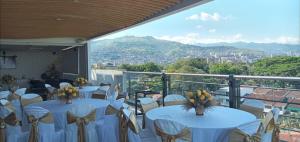 a room with white tables and chairs with a view at Hotel El Alba in Cali