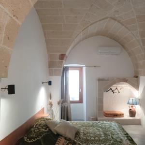 a bedroom with a bed in a room with an archway at Antica Dimora Salentina in Leverano