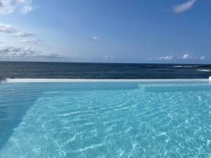 ein Swimmingpool mit Blick auf das Meer in der Unterkunft Ocean View Pico in Madalena