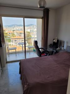 um quarto com uma cama e uma varanda com vista em CANNES Superbe appartement vue mer panoramique em Cannes