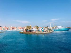 una pequeña isla en medio del agua con barcos en Red Sea Tiba plaza Apartment, en Hurghada