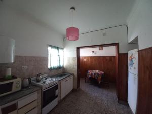 a kitchen with a stove and a sink and a refrigerator at La Casa de Pichona in Miramar