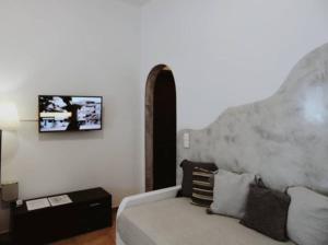 a living room with a couch and a tv on the wall at Lefteris Houses in Karterados