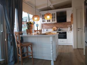 una cocina con armarios blancos y una barra con sillas en The White Swan Suites Beyoglu, en Estambul