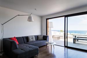 - un salon avec un canapé et une vue sur l'océan dans l'établissement L'Ecrin, à Algajola