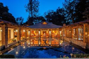 an exterior view of a house with a pool at night at Elewana Arusha Coffee Lodge in Arusha