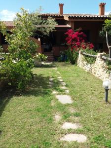 un jardín con rocas frente a una casa en Rey Marina Romantica, en Costa Rei