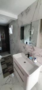 a white bathroom with a sink and a mirror at Sea side apartment in Kotor