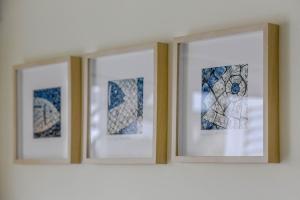 three framed pictures on a shelf on a wall at Penthouse Dali - Cabanas Beach Club in Cabanas de Tavira