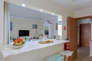 a kitchen with a bowl of fruit on a counter at Penthouse Dali - Cabanas Beach Club in Cabanas de Tavira