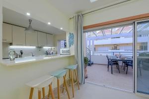 a kitchen and dining room with a table and chairs at Penthouse Dali - Cabanas Beach Club in Cabanas de Tavira +34 photos