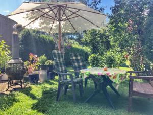 a table and chairs under an umbrella in a yard at Appartement mit Herz in Zeulenroda