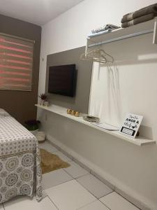 1 dormitorio con 1 cama y TV de pantalla plana en Flat JK 202, en Juazeiro do Norte