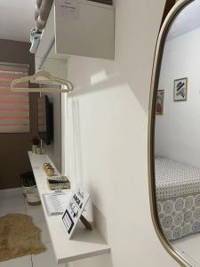 a room with a desk with a mirror and a shelf at Flat JK 202 in Juazeiro do Norte +18 photos