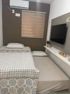 a bedroom with a bed and a flat screen tv at Flat JK 202 in Juazeiro do Norte