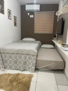 a room with two beds and a rug on the floor at Flat JK 202 in Juazeiro do Norte