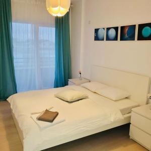 a bedroom with a large white bed with green curtains at Galaxy Residence Villa in Otopeni