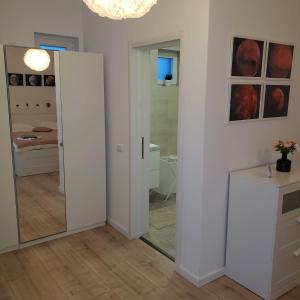 a white room with a mirror and a bathroom at Galaxy Residence Villa in Otopeni