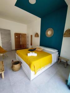 sypialnia z dużym łóżkiem i żółtym kocem w obiekcie Casa Vacanza Le Dune - Mare w mieście Maruggio