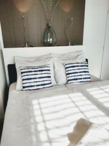 een wit bed met blauwe en witte kussens erop bij Appartement Zuid 5 in Zandvoort