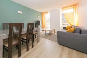 ein Wohnzimmer mit einem Sofa, einem Tisch und Stühlen in der Unterkunft Appart' Fabriques 2 - Mulhouse centre in Mulhouse