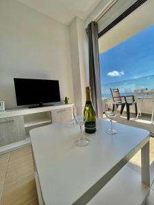 トレモリノスにあるAPARTMENT SOL CARIHUELA TORREMOLINOSのワイン1本とワイングラス2杯(テーブル上)