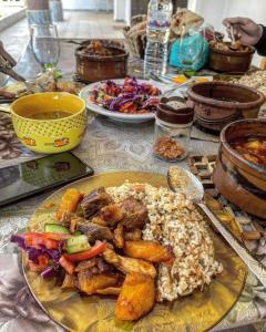une table avec une plaque de nourriture à base de riz et de viande dans l'établissement Rose Guest House, à Louxor