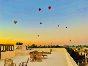 een groep heteluchtballonnen die in de lucht vliegen bij Rose Guest House in Luxor