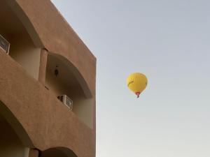 a yellow hot air balloon flying in the sky at Rose Guest House in Luxor