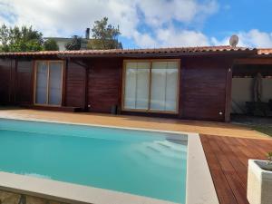 a house with a swimming pool in front of it at Leiria Village casa bungalow in Leiria