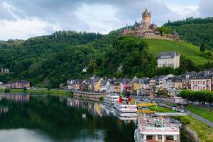 a town with boats in a river with a castle at Ferienwohnung Probst in Ellenz-Poltersdorf