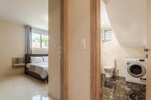 a bedroom with a bed and a washing machine at Kelly's Sunset Apartment 1 Κalamata in Almirón